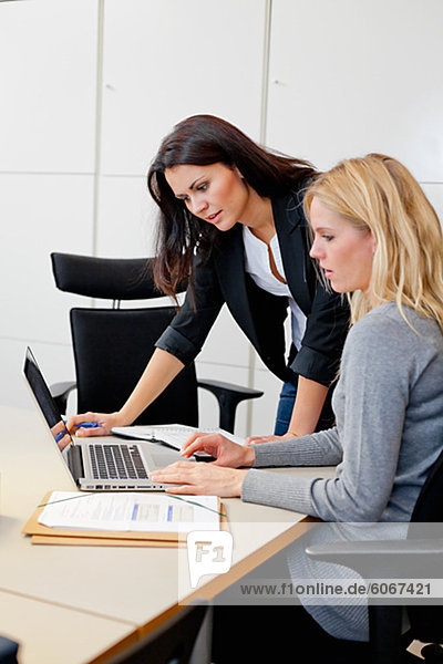 Two female colleagues working together in office environment