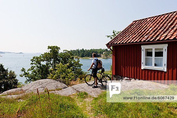 stehend sehen Wohnhaus Fahrradfahrer Steilküste Meer