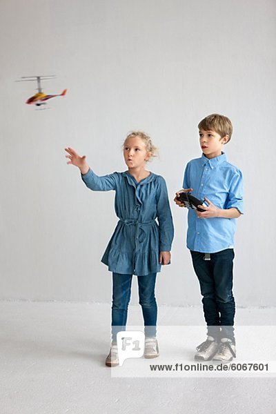 Junge und Mädchen spielen mit Hubschraubermodell