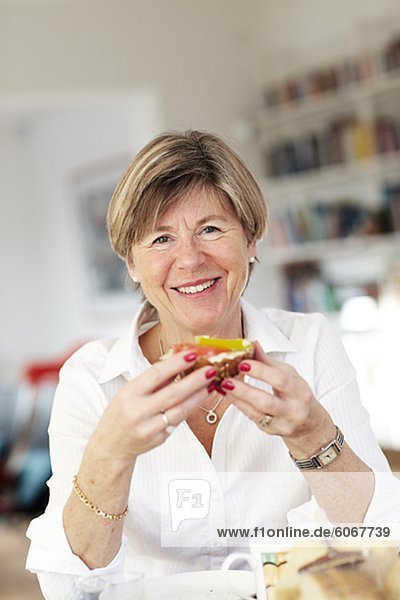 Portrait of mature woman eating breakfast