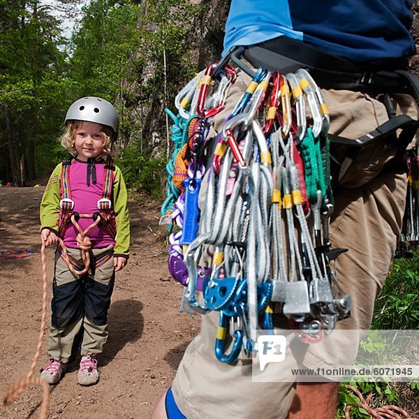 Girl and father equipped before climbing