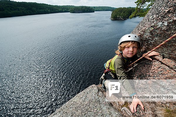 Boy climbing over lake