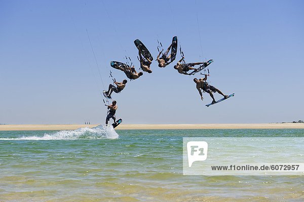 Men kite surfing over sea