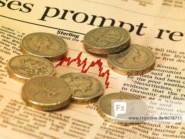 Der Finanzmarkt-Seite einer Zeitung mit britischen Pfund-Münzen
