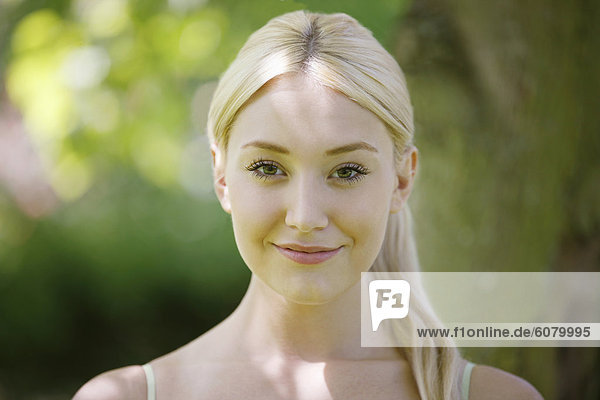 Ein Porträt einer jungen blonde Frau lächelnd