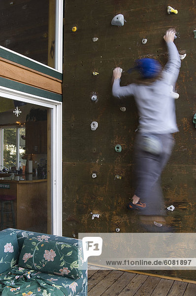 A young man climbs an indoor climbing wall inside a residence in Whitefish  Montana.