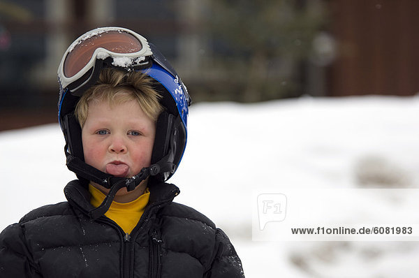 Skihelm  Skibrille  Junge - Person  Schutzbrille  Ski  Zunge herausstrecken  Helm