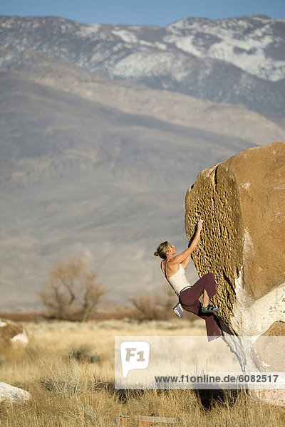 Young woman bouldering in Bishop  CA.