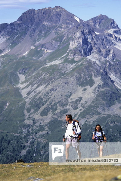 A couple hiking the Swiss Haute Route from Verbier to Zermatt across the Alps.