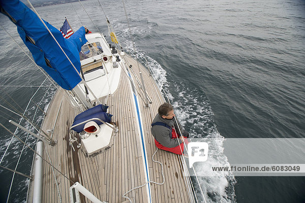A man hanging out on the deck of his sailboat.