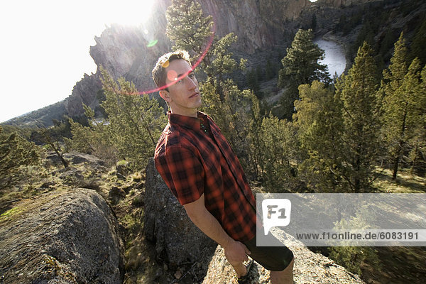 A man in a plaid shirt standing above the Crooked River  Oregon. (solar flare)