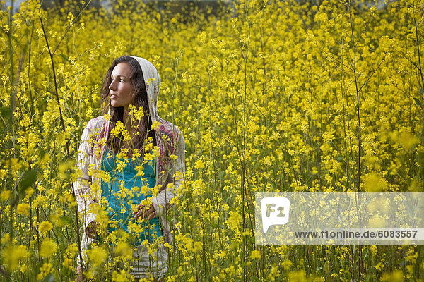 entfernt  stehend  Frau  sehen  Blume  gelb  Feld  jung  Kleidung  Kapuze