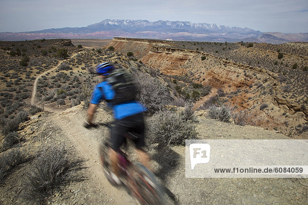 Man mountain biking down a desert trail near Hurricane  Utah.