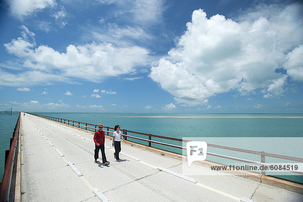 A couple walk along a bridge in Florida.