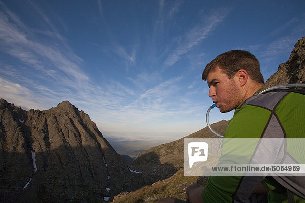 A man taking a water break on a ridge in the Sangre de Cristos Mountains  Colorado.