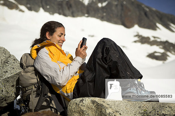 A Latina woman text messages while in the mountains.