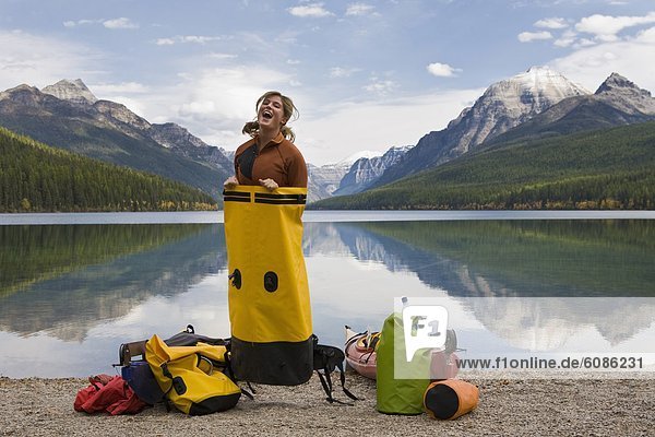 Portrait of young female kayaker having fun in front of a beautiful lake deep in Glacier National Park.