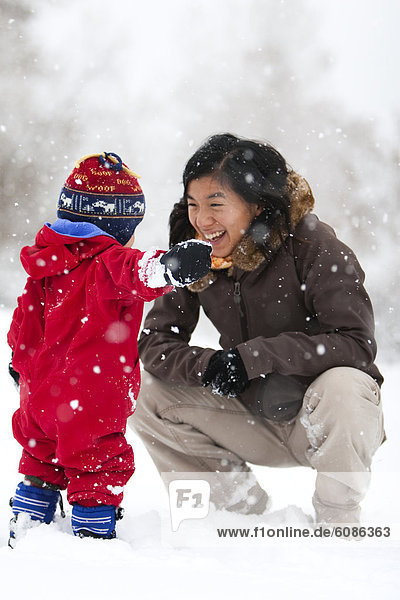 A mother plays with her toddler son in his first big snowstorm in Fort Collins  Colorado.