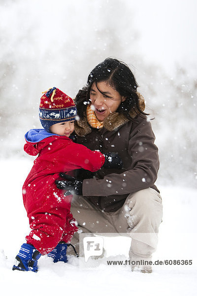 A mother plays with her toddler son in his first big snowstorm in Fort Collins  Colorado.