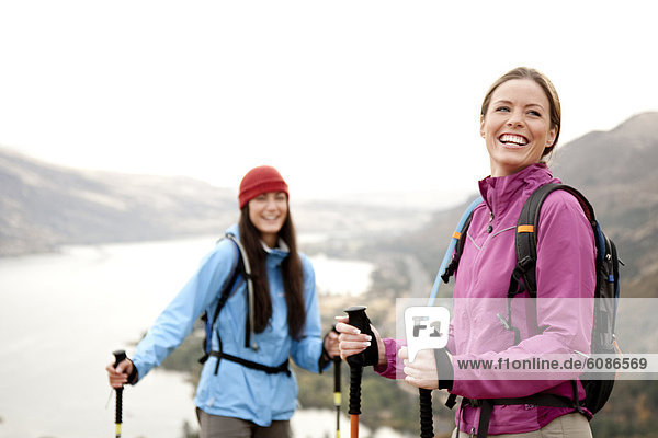 Two females taking a break while hiking with the Columbia Gorge in the background.