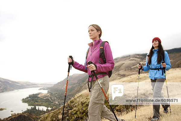 Two females hiking in the Columbia Gorge  Oregon. The Columbia River flowing in the distance.
