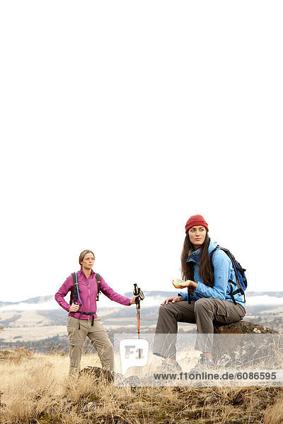 Two females take a break to check the compass while hiking in the Columbia Gorge  Oregon in autumn.