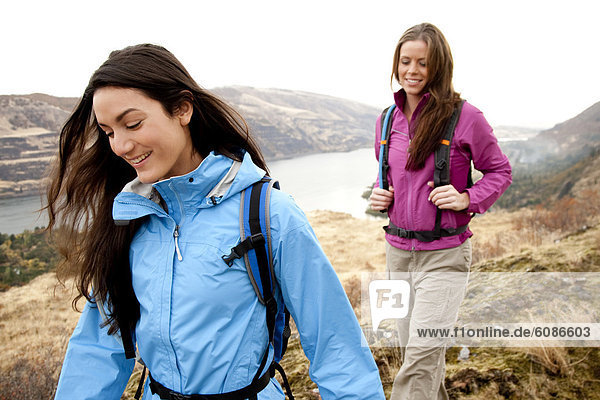 Two females in bright clothes hiking in the Columbia River Gorge  Oregon.