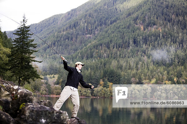 A man fly fishes Lake Crescent in Washington's Olympic National Park.