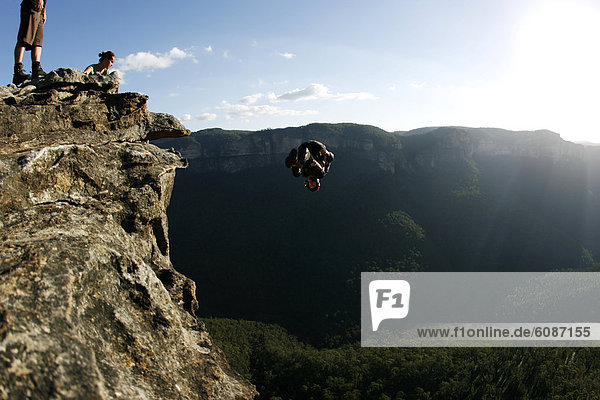 A BASE jumper performs a front flip off a cliff in the Blue Mountains  New South Wales  Australia.