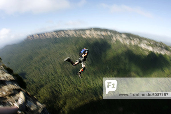 A BASE jumper leaps off a cliff in the Blue Mountains  New South Wales  Australia.