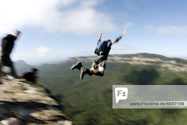 A BASE jumper leaps off a cliff in the Blue Mountains  New South Wales  Australia.