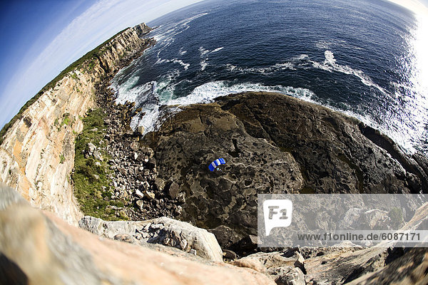 A BASE jumper glides his parachute to a landing in Sydney  New South Wales  Australia. (fisheye lens)