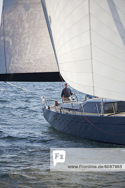 A crew races a modern ocean-going sailing yacht.