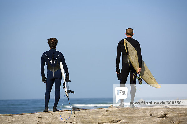Two men stand with surfboards under their arms on The Lost Coast  California.
