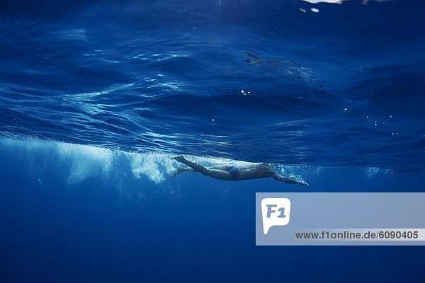 Underwater view of a swimmer enjoying a relaxing swim in the tropical waters off of Mana Island  Fiji.