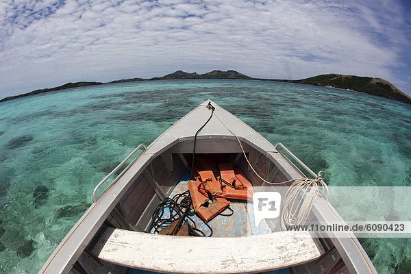 A boat glides across the reef in the Yasawas Islands  Fiji.