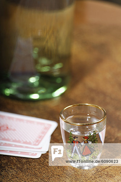 Germany  Schnapps in glass with cards and bottle on table