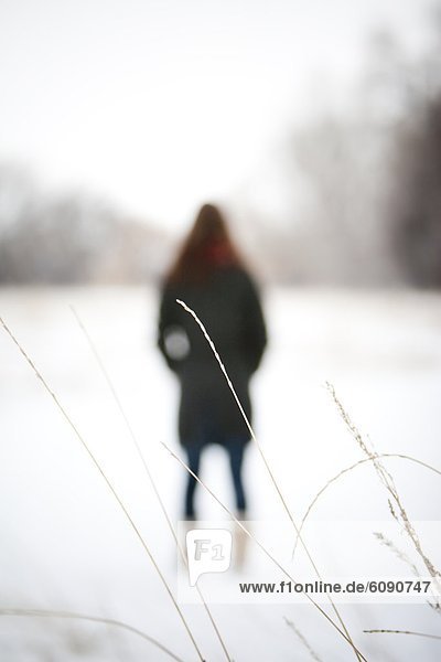 Frau  Winter  Tag  gehen  Schnee  Feld  Fokus auf den Vordergrund  Fokus auf dem Vordergrund  Gras  Colorado  gefroren  Bewölkung  bewölkt  bedeckt