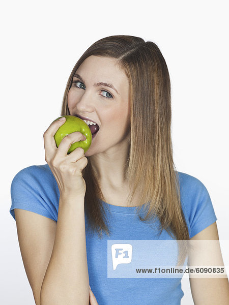 Junge Frau isst Apfel  Portrait