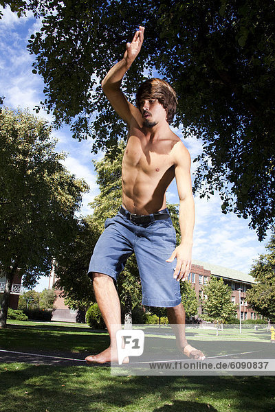 A professional slackliner plays around on the slackline on a university campus in Missoula  Montana.