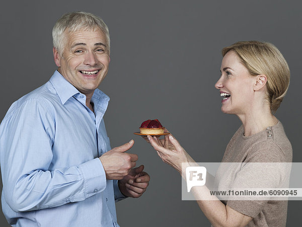Mature couple with cake  smiling