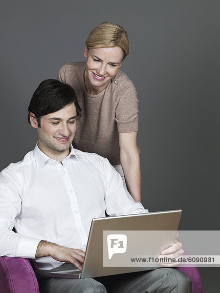Man and woman using laptop  smiling