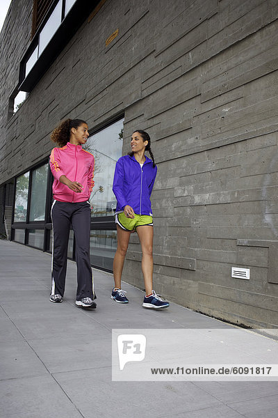 Two girlfriends walking and talking in their running outfits in San Diego.