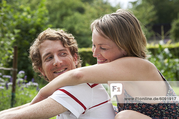 Woman embracing man in allotment garden