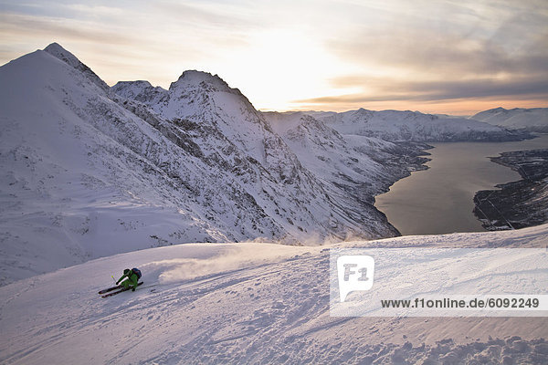 Norway  Lyngen  Skier skiing downhill at sunset