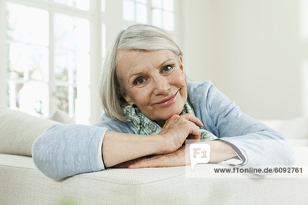 Senior woman on couch  smiling  portrait