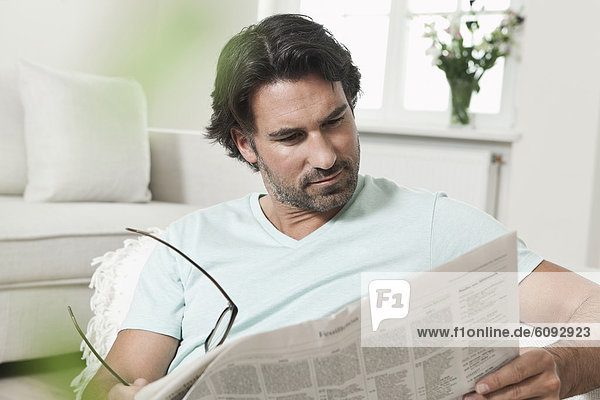 Mature man reading newspaper