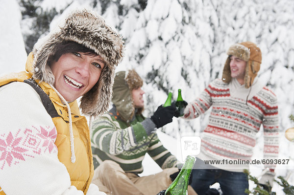 Österreich  Salzburg  Junge Frau mit Flasche  Menschen im Hintergrund