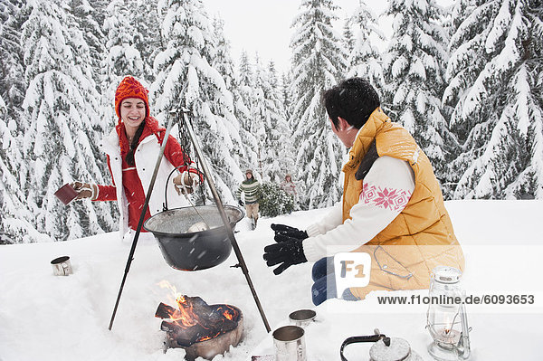 Österreich  Salzburg  Mann und Frau am Kamin  Menschen mit Weihnachtsbaum im Hintergrund