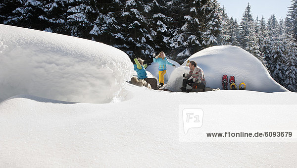 Österreich  Salzburger Land  Familie beim Iglu sitzend